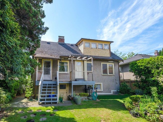 Rear view of property featuring a chimney, stucco siding, and stairway | Image 19