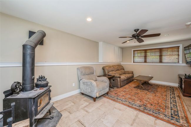 Lower level with a ceiling fan, a wood stove, and recessed lighting | Image 16