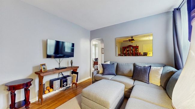 Living room featuring arched walkways, wood finished floors, and ceiling fan | Image 7
