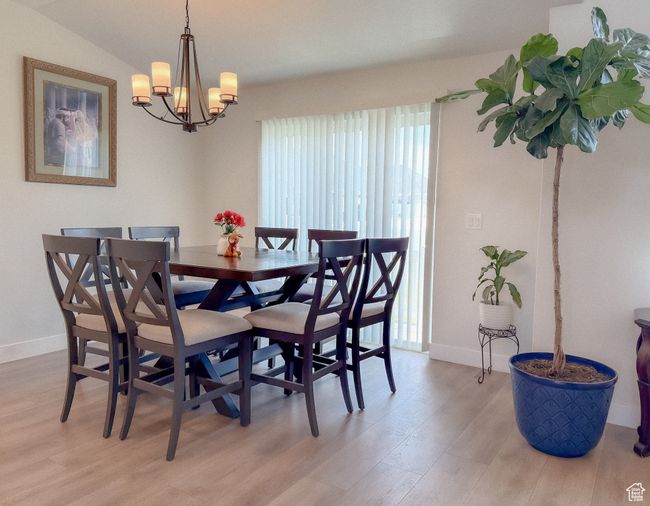 Dining space with light wood finished floors and a chandelier | Image 7