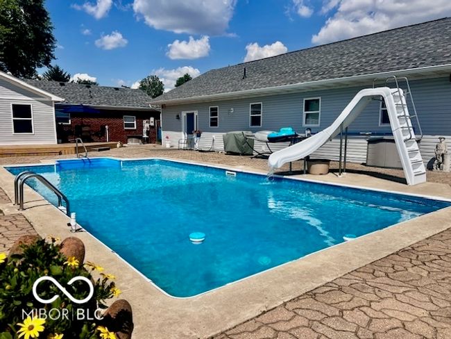 rear view of house featuring a deck, a lawn, an outdoor fire pit, brick siding, and central AC unit | Image 70