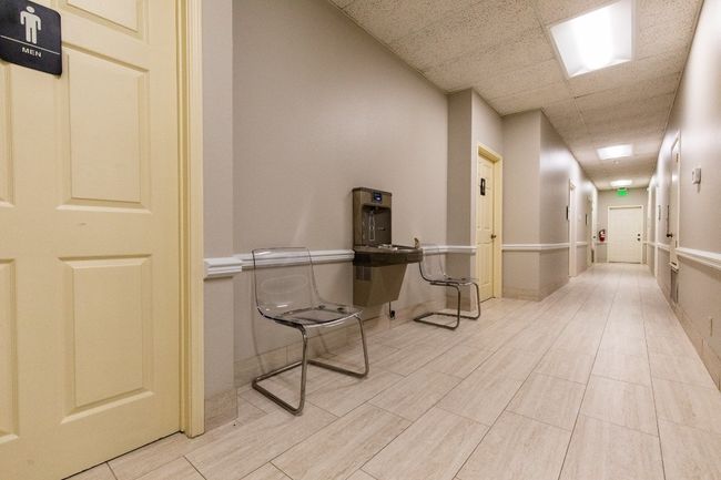 Hallway with a drop ceiling and baseboards | Image 11