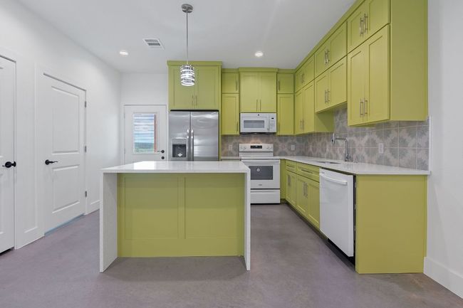 Kitchen featuring green cabinets, white appliances, visible vents, and a sink | Image 14