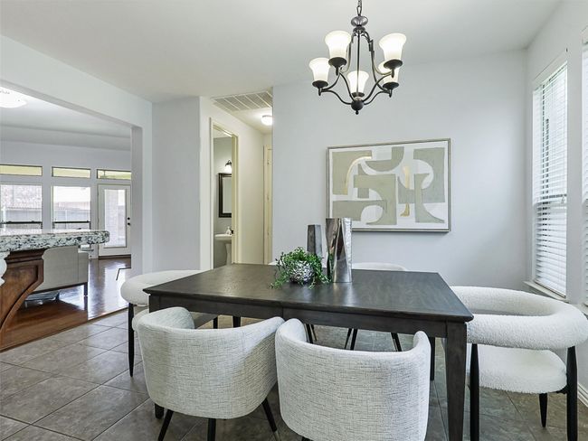 Dining room with a chandelier and dark tile patterned floors | Image 14
