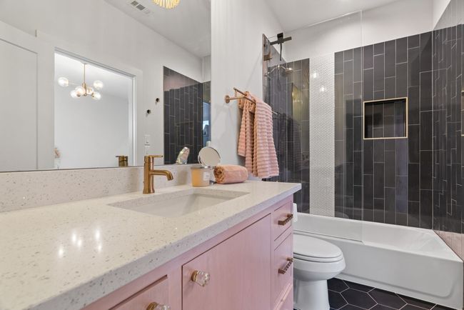 Full bathroom with vanity, tile patterned flooring, shower / bath combination, and a chandelier | Image 32