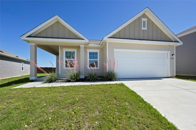 View of front of house featuring driveway, a garage, board and batten siding, and a front yard | Image 4