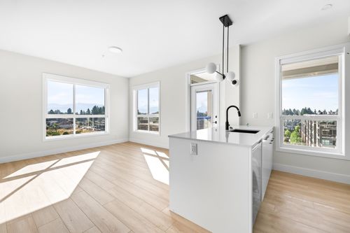 White kitchen island with a dark faucet, white cabinetry, and a modern globe pendant light | Card Image