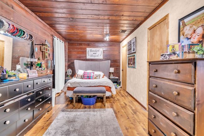 Bedroom with wood ceiling, wooden walls, and wood finished floors | Image 18