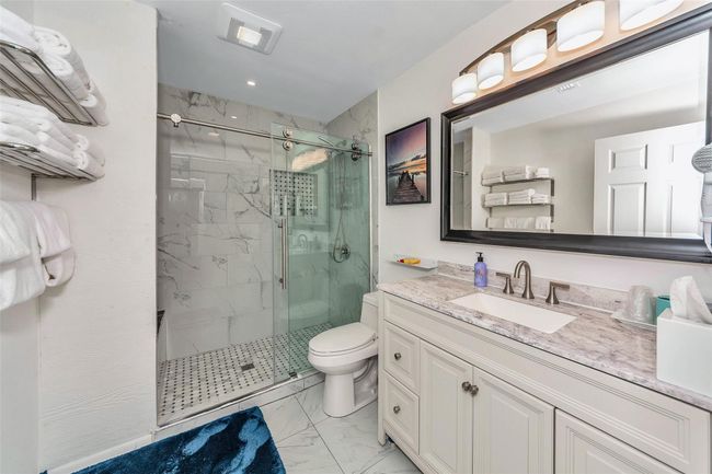Bathroom with marble finish flooring, toilet, a marble finish shower, vanity, and recessed lighting | Image 17