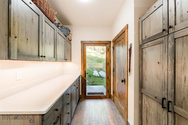 The laundry room has plenty of additional storage space. It is situated close to the kitchen so it is an ideal butler's pantry. | Image 34