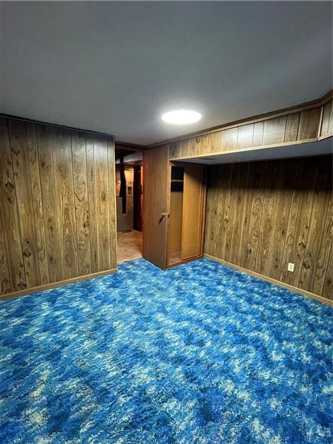 Empty room with wood walls and carpet floors | Image 31