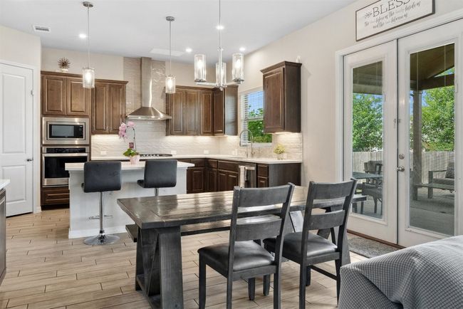 The breakfast area offers a sunny spot to start your day, with large windows that bring in natural light and provide a view of the backyard | Image 10
