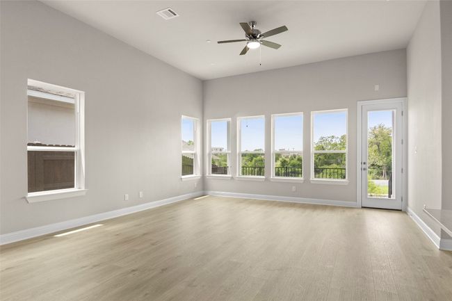 Spare room featuring light wood-style flooring, baseboards, and ceiling fan | Image 8