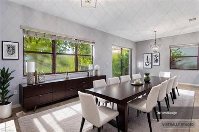 Dining room featuring tile walls, a notable chandelier, and light tile patterned floors | Image 3