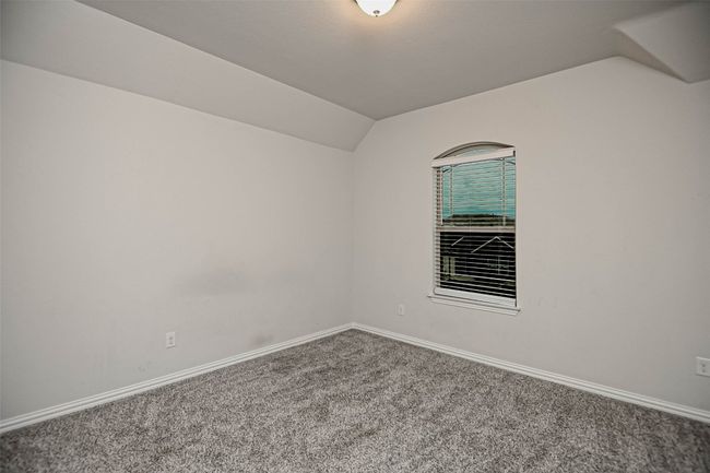 Carpeted empty room with baseboards and lofted ceiling | Image 27