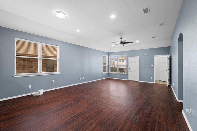 Unfurnished living room with baseboards, arched walkways, a ceiling fan, recessed lighting, and wood finished floors | Image 18