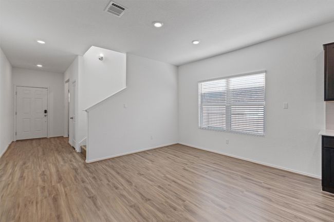 Unfurnished living room with baseboards, recessed lighting, visible vents, and light wood-style floors | Image 5
