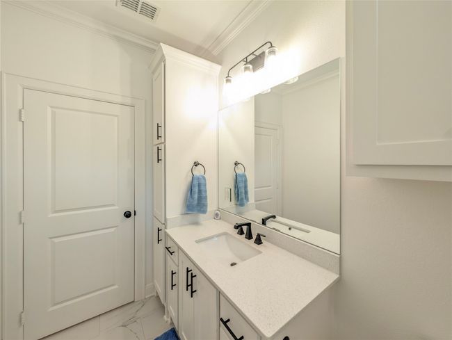 Bathroom featuring vanity, ornamental molding, and marble look tile flooring | Image 29