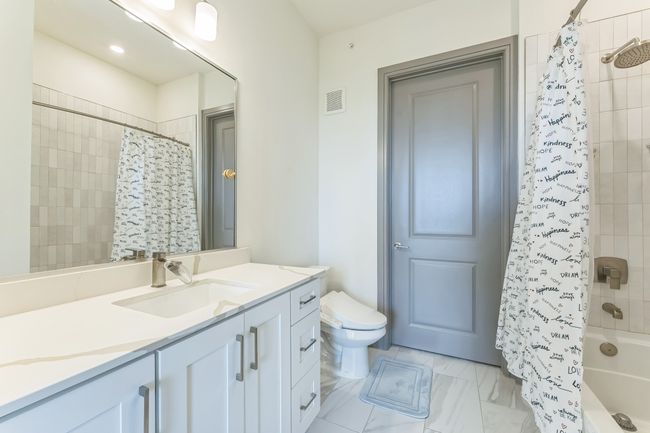 Full bathroom featuring vanity, shower / bath combination with curtain, and marble look tile flooring | Image 16