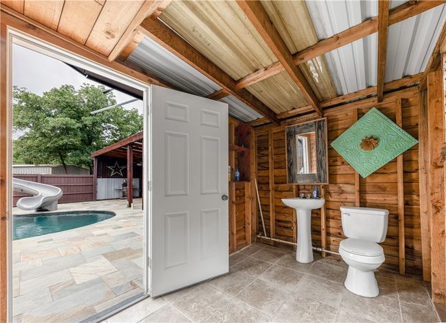 Bathroom in pool house featuring toilet and stone finish flooring | Image 29