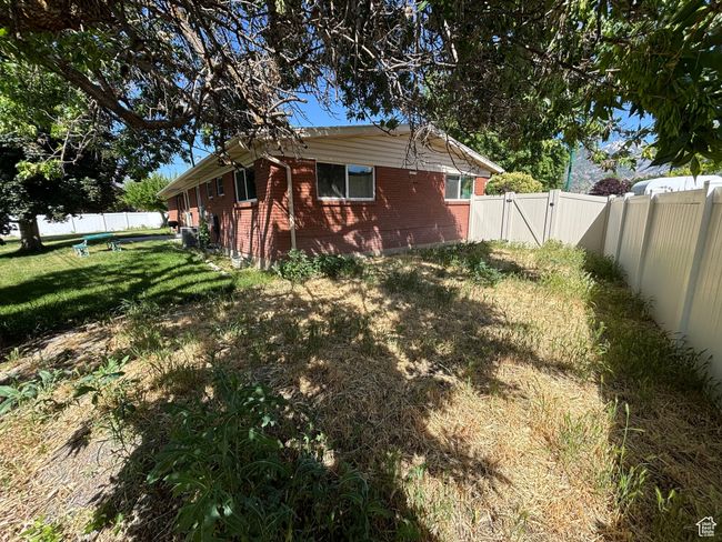 Back of house with brick siding and a gate | Image 7