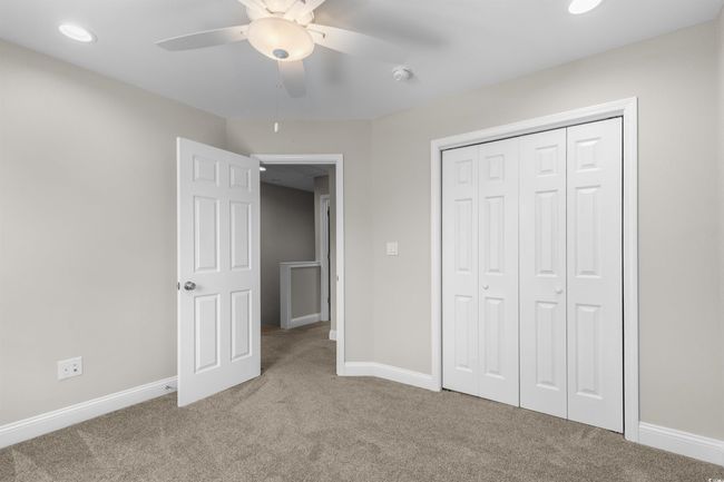 Unfurnished bedroom with carpet flooring, baseboards, a closet, and ceiling fan | Image 32