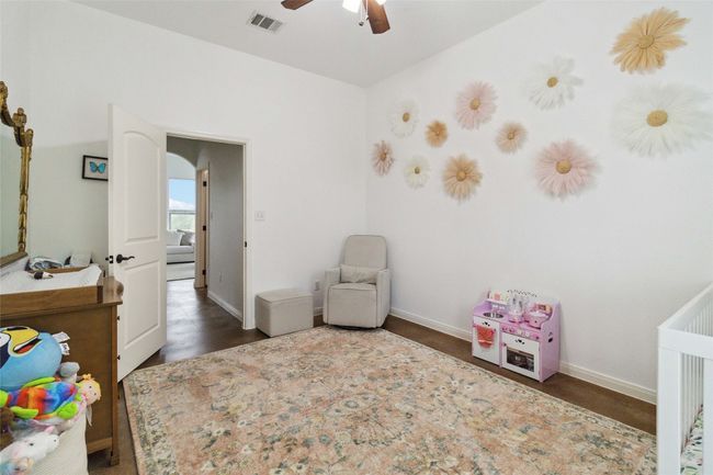 Bedroom with a nursery area, baseboards, arched walkways, and ceiling fan | Image 19