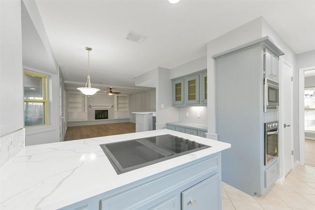 View from cook top stove to breakfast area and living room. | Image 7