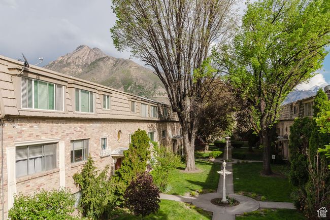 View of home's exterior with brick siding, a mountain view, and a lawn | Image 23