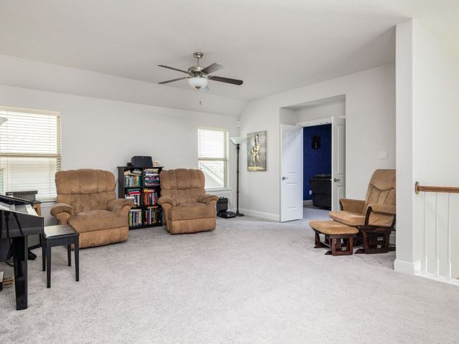Living area with baseboards, vaulted ceiling, ceiling fan, and carpet flooring | Image 20