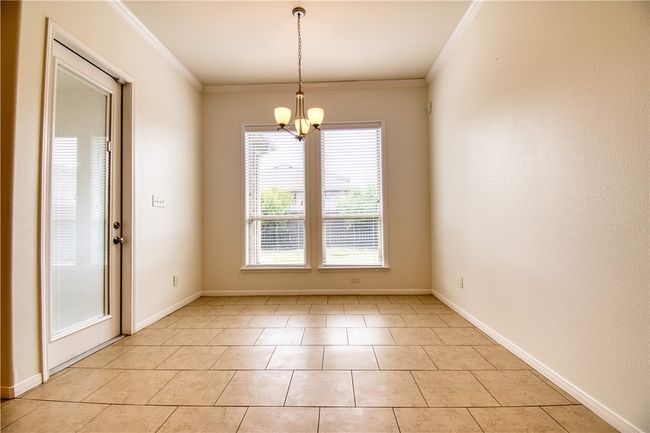 Unfurnished room with an inviting chandelier, crown molding, and baseboards | Image 13
