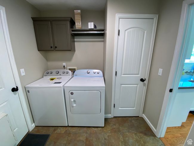 Laundry room with washing machine and dryer, cabinet space, baseboards, and stone finish floors | Image 11