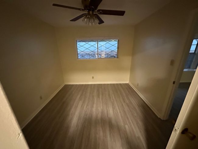 Unfurnished room with baseboards, a ceiling fan, and dark wood finished floors | Image 23