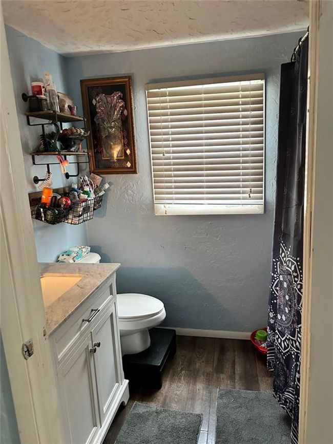 Full bathroom featuring vanity, baseboards, wood finished floors, and a textured wall | Image 22