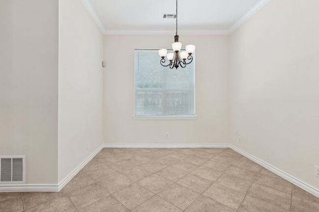 Unfurnished room with ornamental molding, a chandelier, and light tile patterned flooring | Image 11