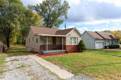 View of front of property with a front yard, a garage, and covered porch | Image 1