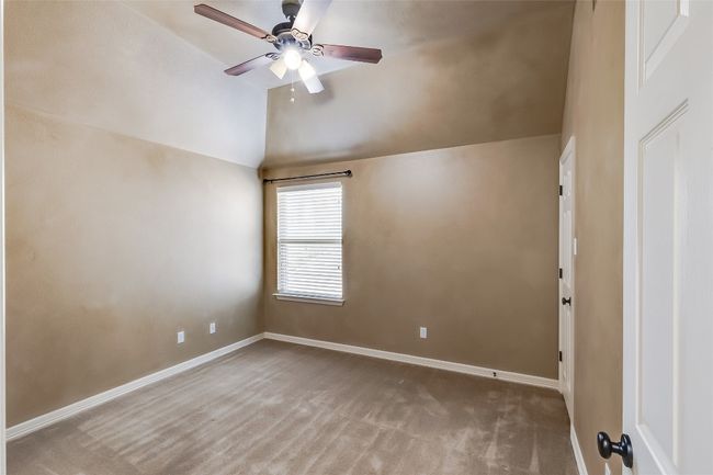 Unfurnished room with baseboards, carpet floors, vaulted ceiling, and a ceiling fan | Image 32