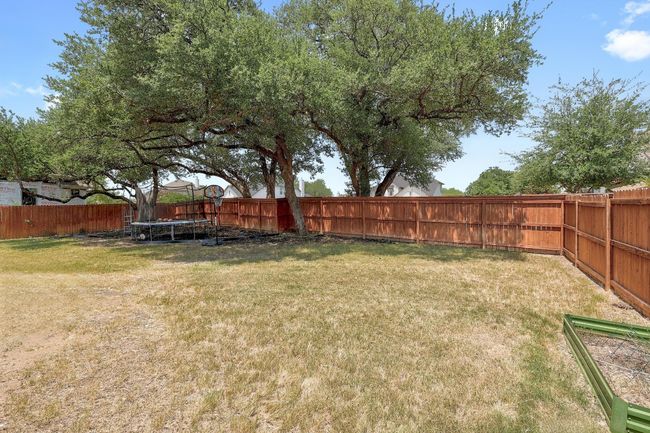 Fenced backyard featuring a trampoline | Image 36