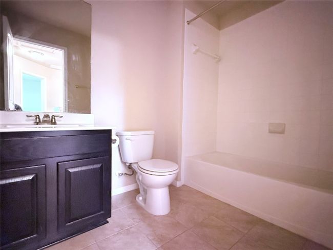 Full bath featuring vanity, tile patterned flooring, and washtub / shower combination | Image 13