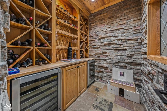wine room with wood ceiling and beverage cooler | Image 76