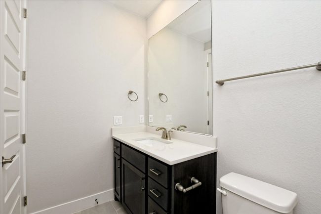 Bathroom featuring baseboards, toilet, tile patterned flooring, and vanity | Image 26