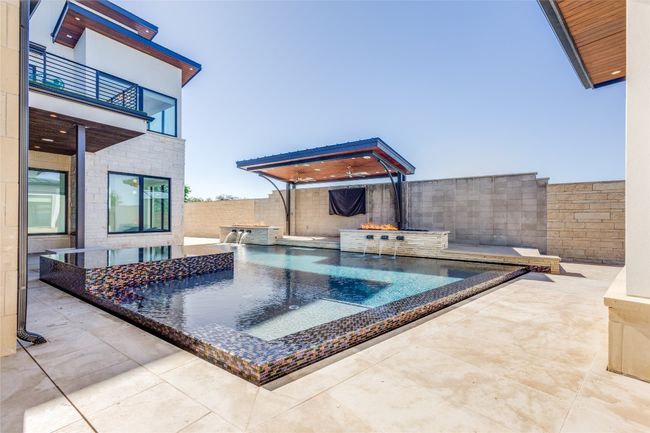 View of swimming pool with a fenced backyard, a hot tub, a patio area, and a fenced in pool | Image 4