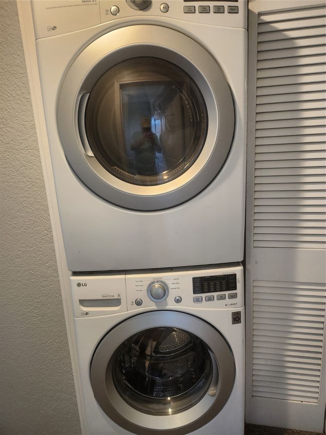 Washroom featuring laundry area, stacked washer / dryer, and a textured wall | Image 10