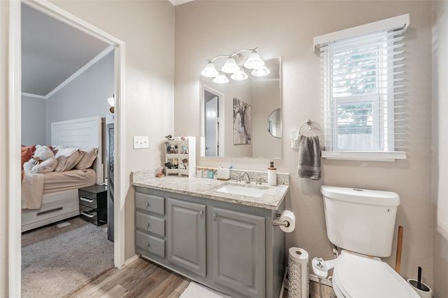 Bathroom featuring wood finished floors, vanity, and ornamental molding | Image 23