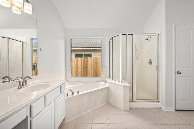 Primary Bathroom featuring Double Vanity, Soaking Tub, Glass Shower, and Walk-In Closet | Image 21
