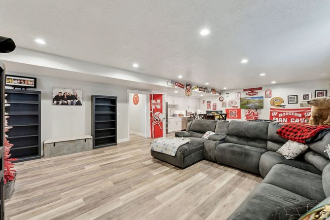 Living area featuring wine cooler, recessed lighting, light wood-style flooring, and indoor bar | Image 30