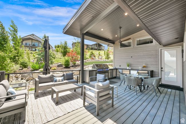 Wooden terrace with an outdoor living space, a ceiling fan, and outdoor dining area | Image 61