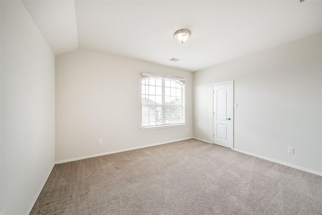 Bright, spacious upstairs bedroom 1 with neutral walls, carpeted floor, large window for natural light, and a white door. Ideal for a bedroom or office space. | Image 20