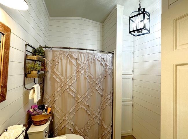 The farmhouse theme continues with the updated lighting, shiplap and the tin accented ceiling on this bathroom. | Image 10