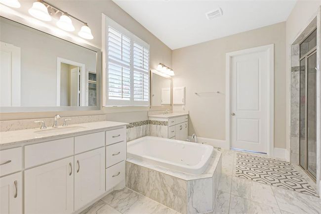 Marble-look tile floors, plantation shutters, and neutral finishes create a bright and relaxing retreat with ample room for personalization. | Image 27